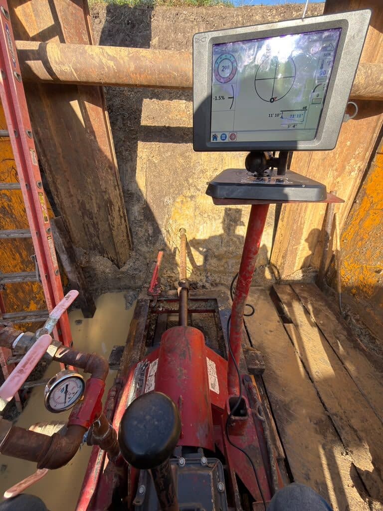 Auger boring machine set on track with a guidance monitor