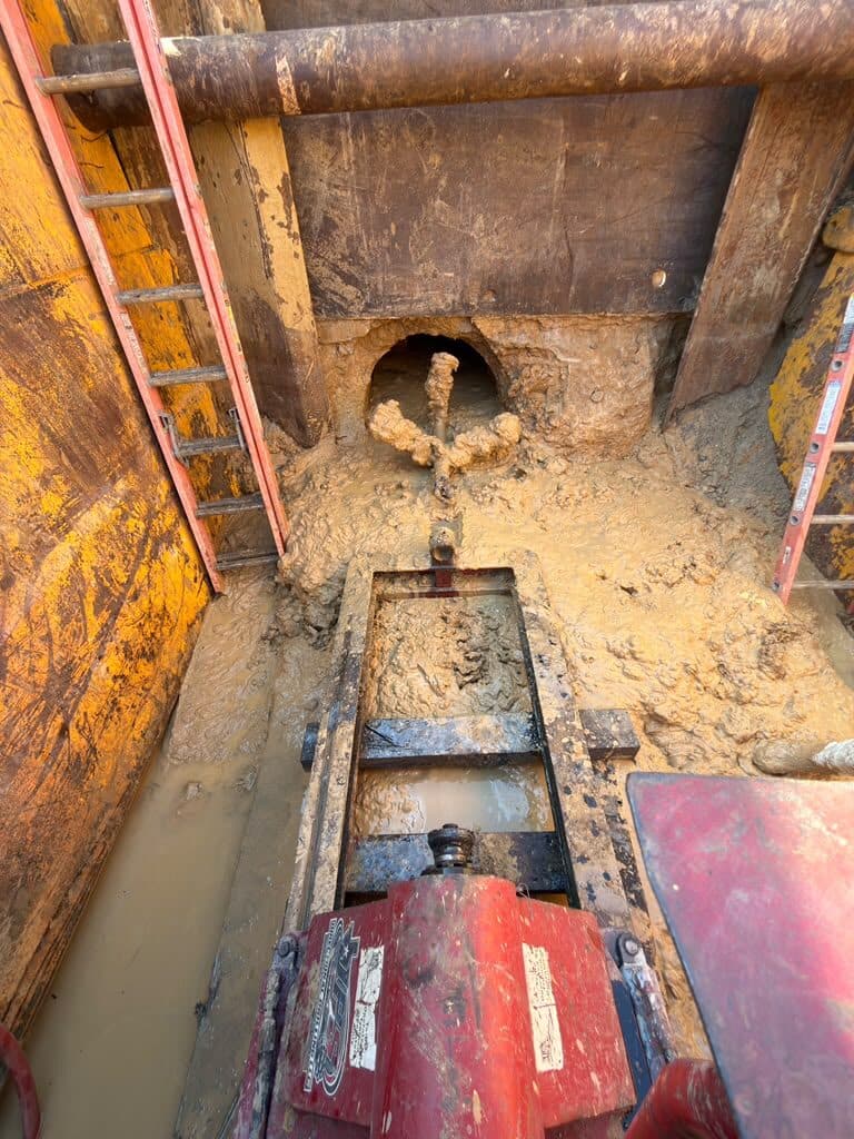Completed casing through the wall of a shored bore pit