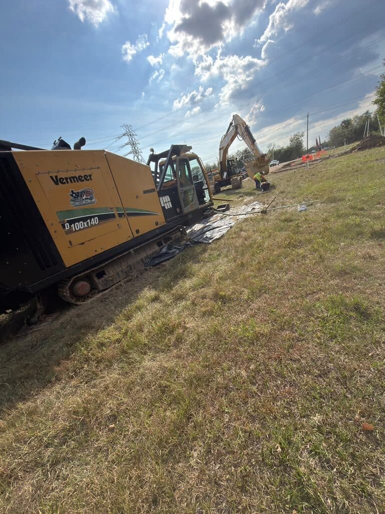 Boring equipment and excavator staged on a right of way